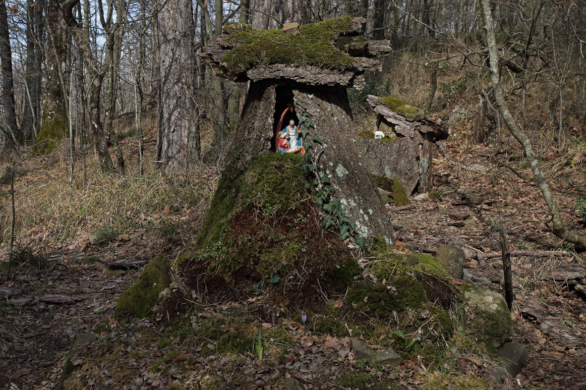 Riproduzione con la Sacra Famiglia inserita in un tronco d'albero con tetto di muschio, legno e pietre
