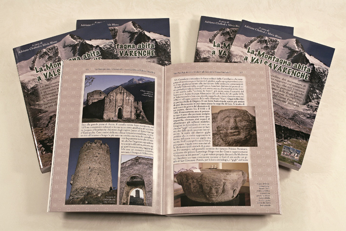 foto con alcune copie del libro La Montagna abita a Valsavarenche, in primo piano il libro aperto su due pagine del primo capitolo corredate di foto